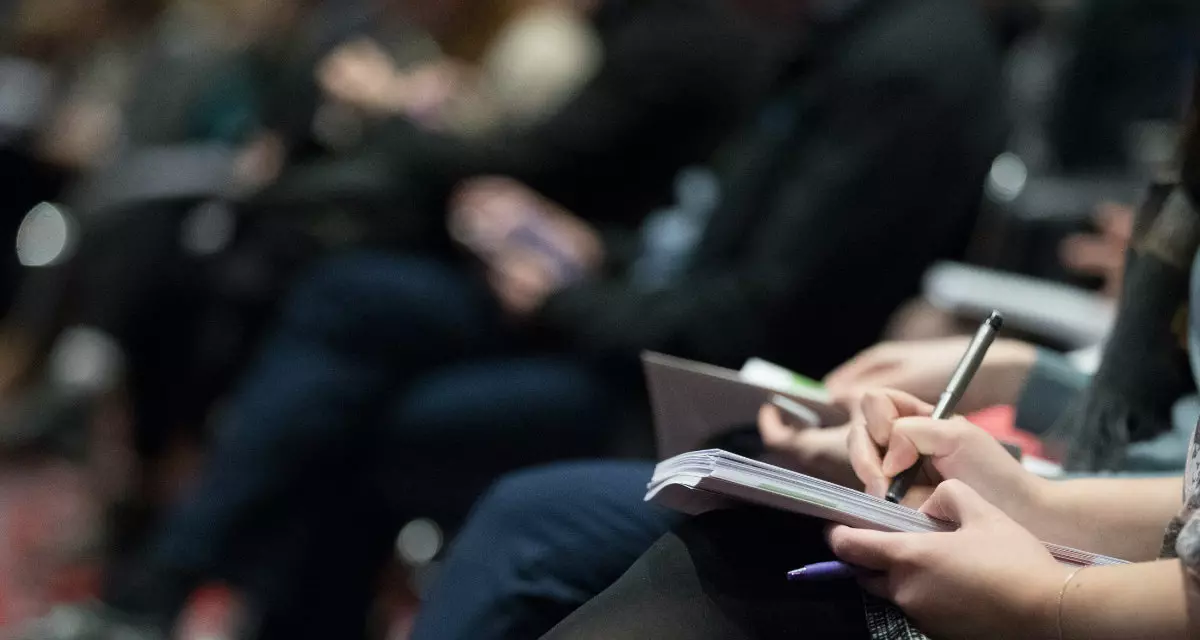 Foto: The Climate Reality Project|Unsplash Menschen sitzen nebeneinander, nehmen zum Teil Notizen.