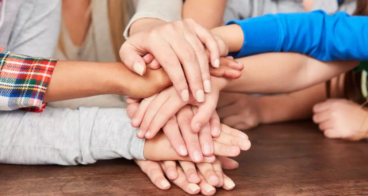 Foto: Gestapelte Hände | Adobe Stock | Robert Kneschke | 303790144 Kinder Gruppe stapelt Hände für Netzwerk